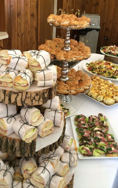 Estación de sándwiches gourmet y bocados sobre bases de madera